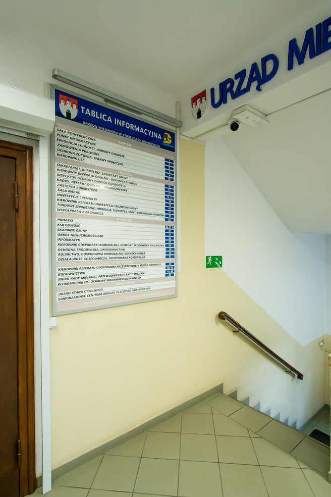 Zdjęcie przedstawia tablicę informacyjną znajdującą się w budynku urzędu.
