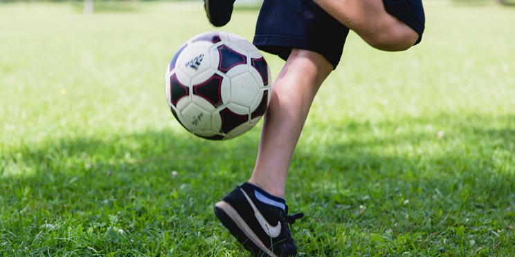 Na zdjęciu chłopiec grający w piłke